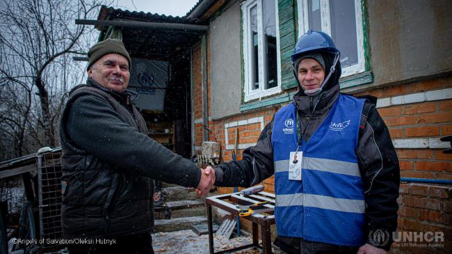 two men shaking hands in front of the house